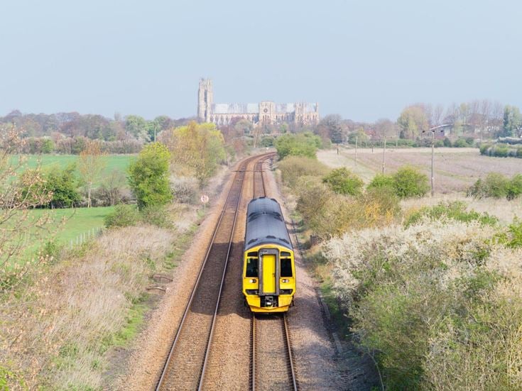 a train travels down the tracks towards Beverley Minster
