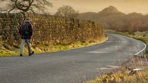A retiree strides out for a sunny early morning walk along the road across Baildon Moor.