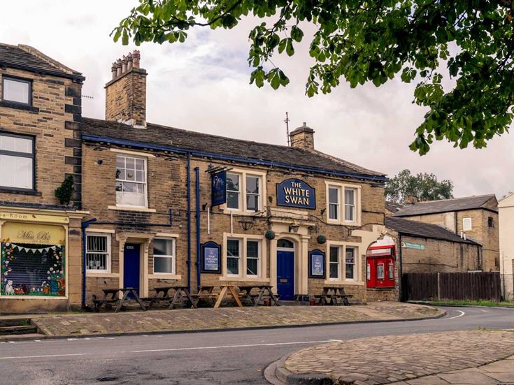 The White Swan pub in Bradford, with a cobblestone pavement outside the building.