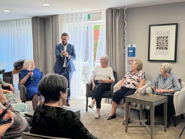 a person speaking to a group of people in a room