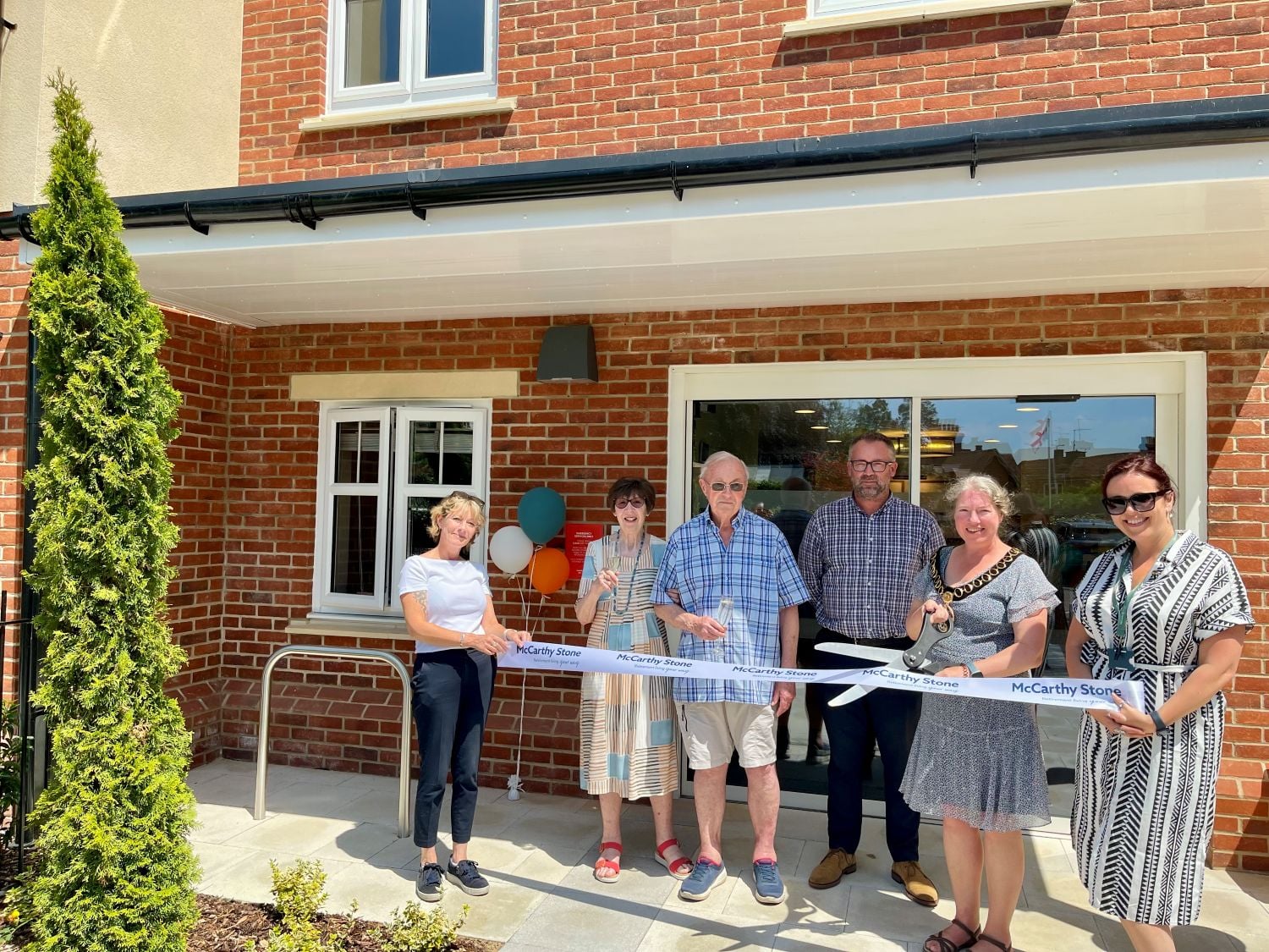 Councillor Penny Flux cutting the ribbon at the grand opening of Flora Place.