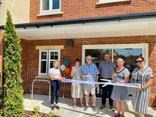 Councillor Penny Flux cutting the ribbon at the grand opening of Flora Place.