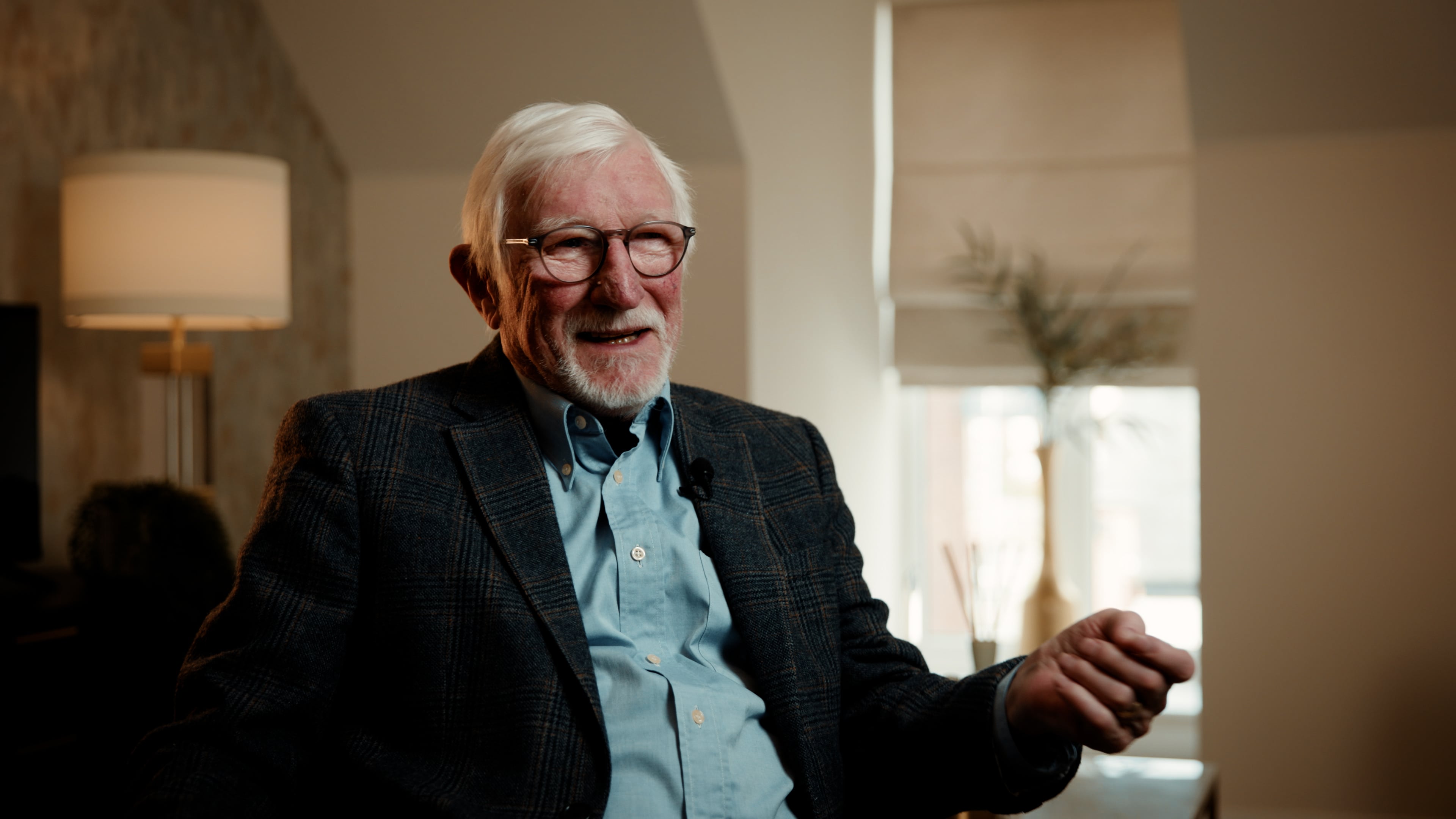 a man with glasses smiling