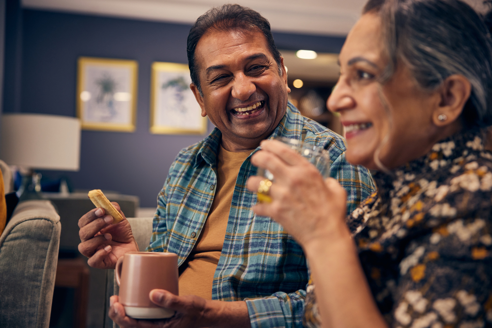 An older couple enjoying tea and biscuits