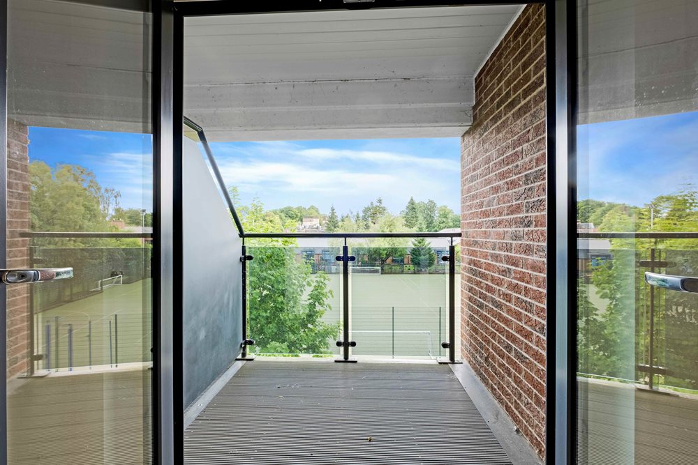 a room with windows and a brick wall with a view of trees