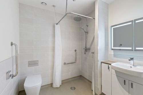 a bathroom with a shower unit and toilet