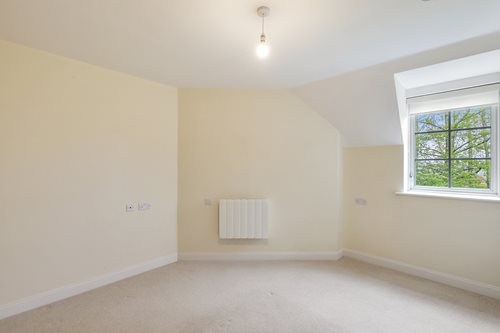 a room with a window and a white wall