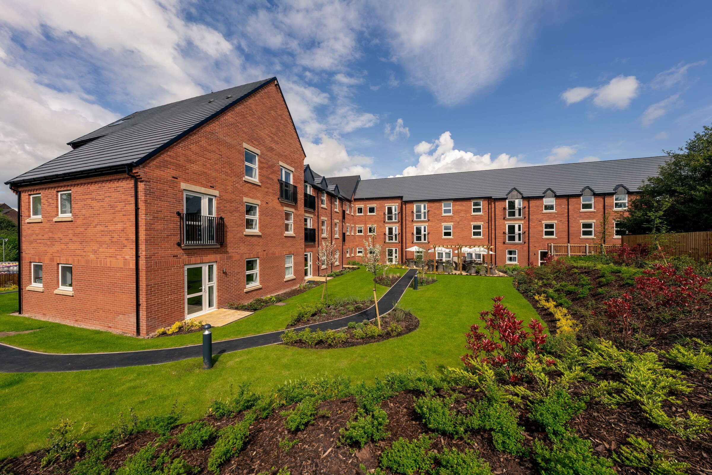a brick building with a grass lawn
