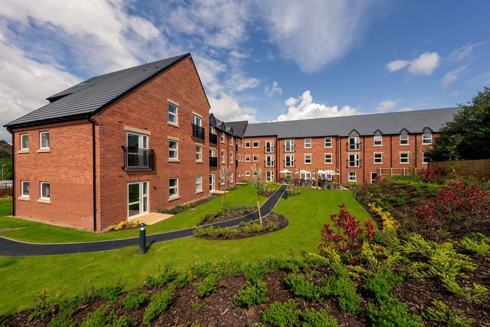 a brick building with a grass lawn