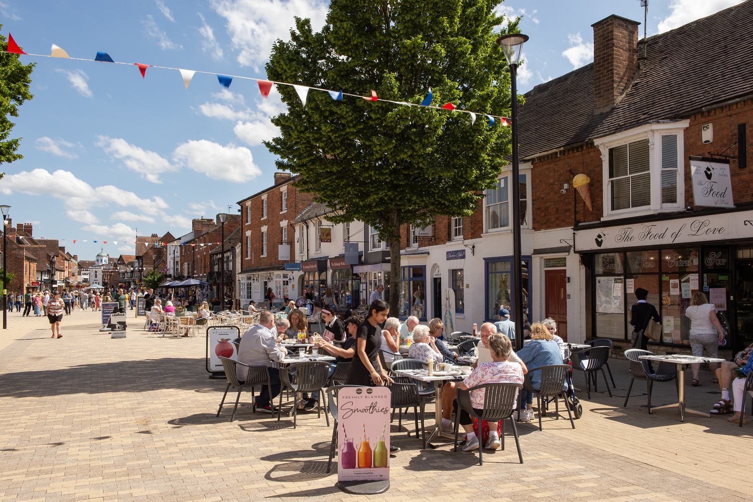 a group of people sitting outside at tables outside a restaurant