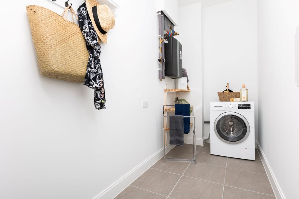 a laundry room with a washing machine and clothes on the wall