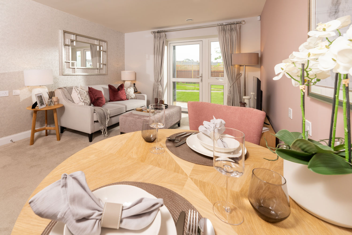 a dining room table with a white couch and a white table with white flowers