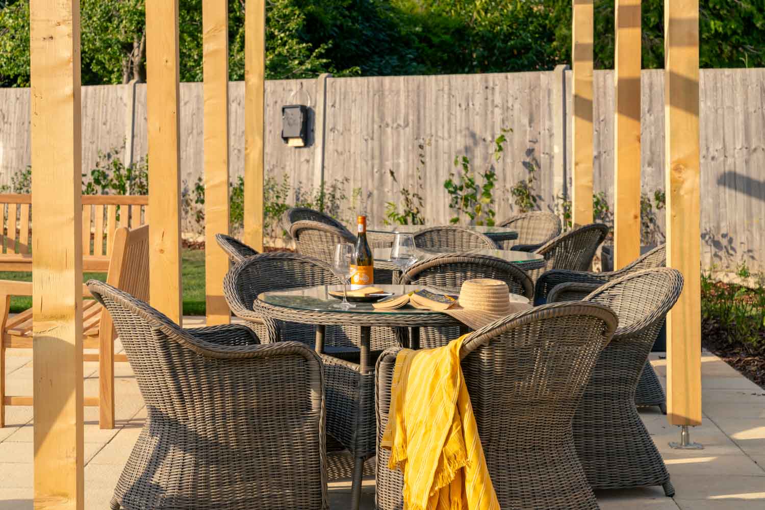 a table set with chairs and a wood fence