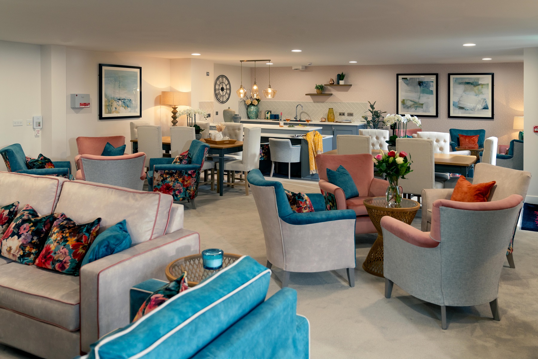 a living room with blue chairs and a table with flowers on it