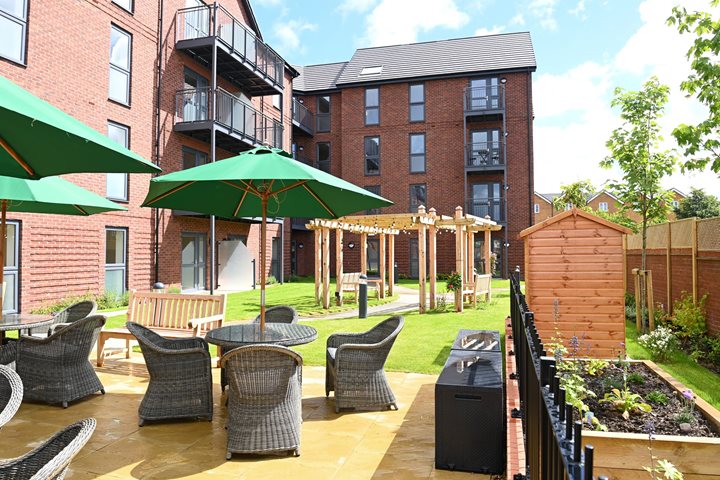 a patio with a table and chairs and a green umbrella