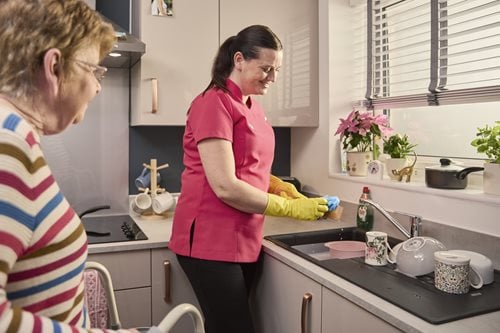 a person washing a person's hands in the kitchen