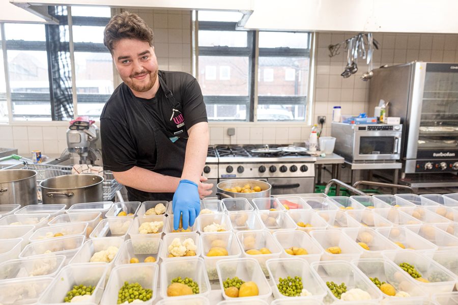 a person in a kitchen with many food items