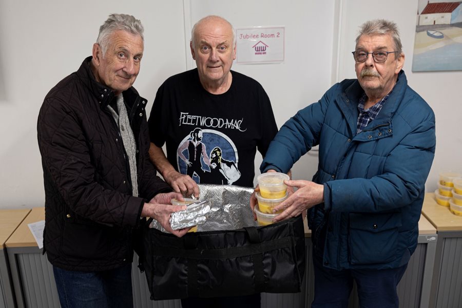 a group of men holding a bag of food