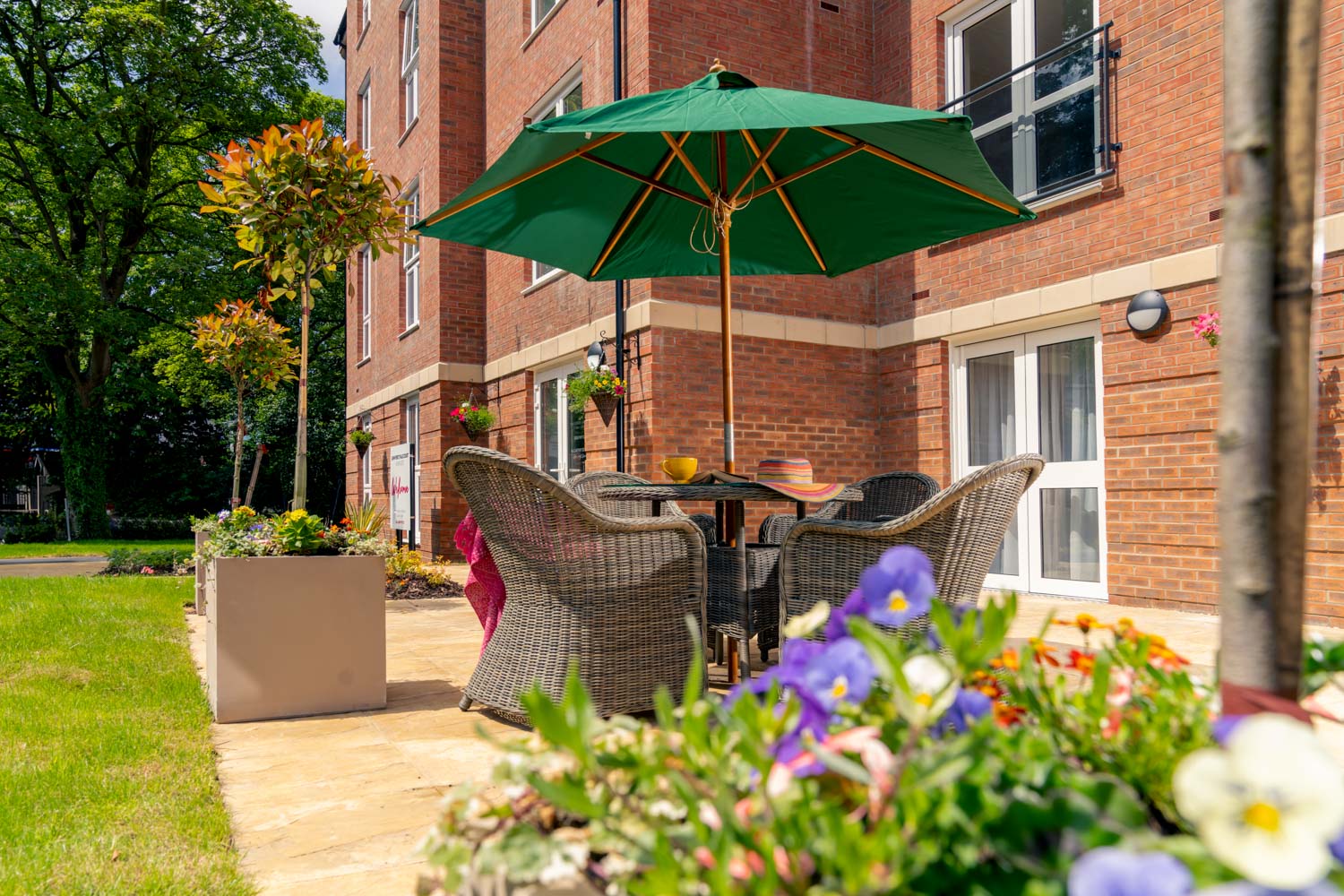 a patio with a table and chairs and a green umbrella