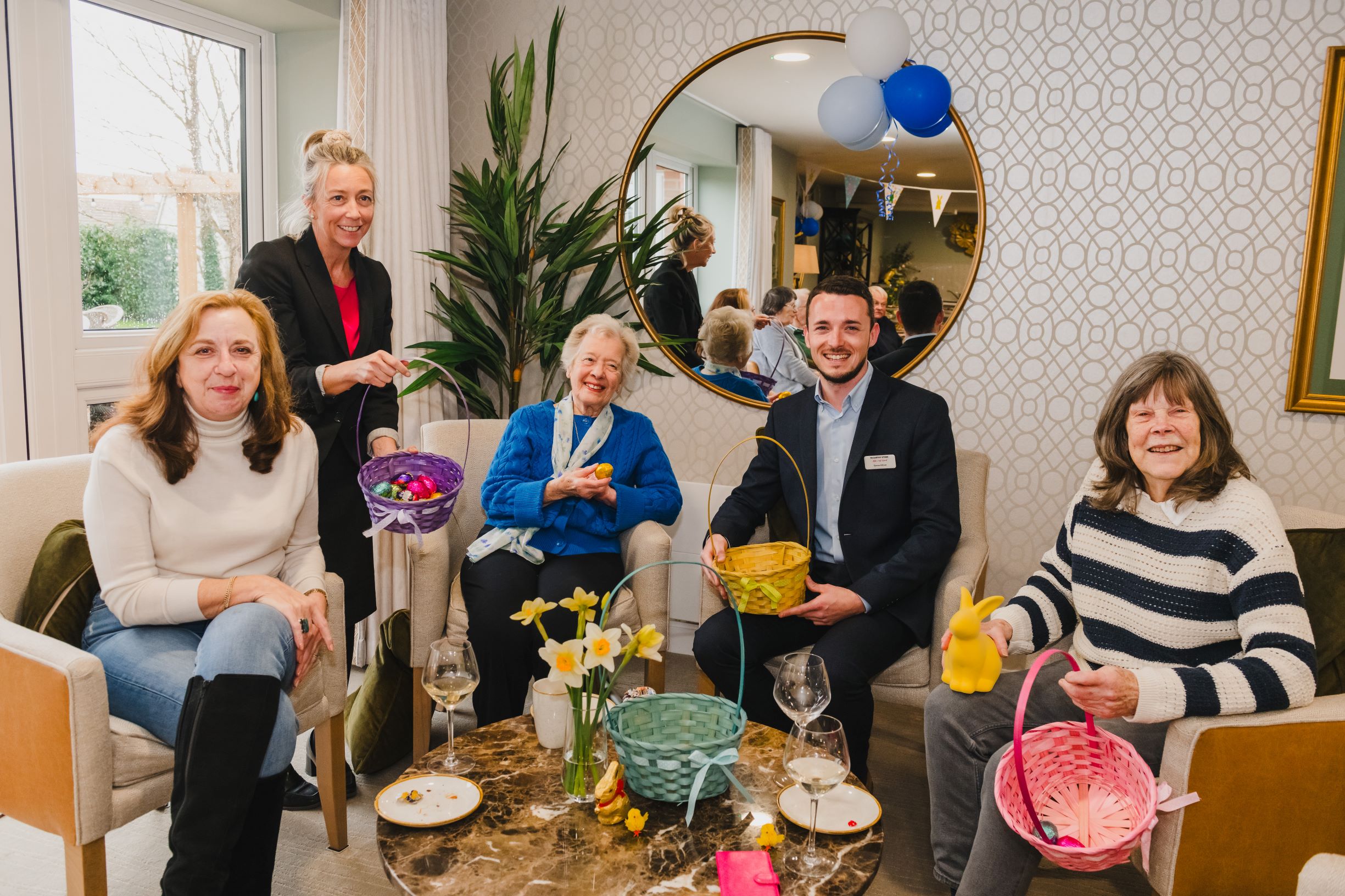 a group of people sitting around a table with flowers