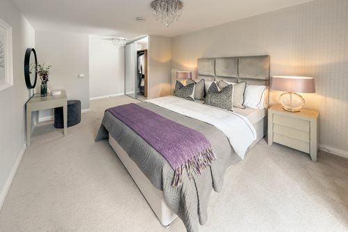 a bedroom with a bed and a purple blanket