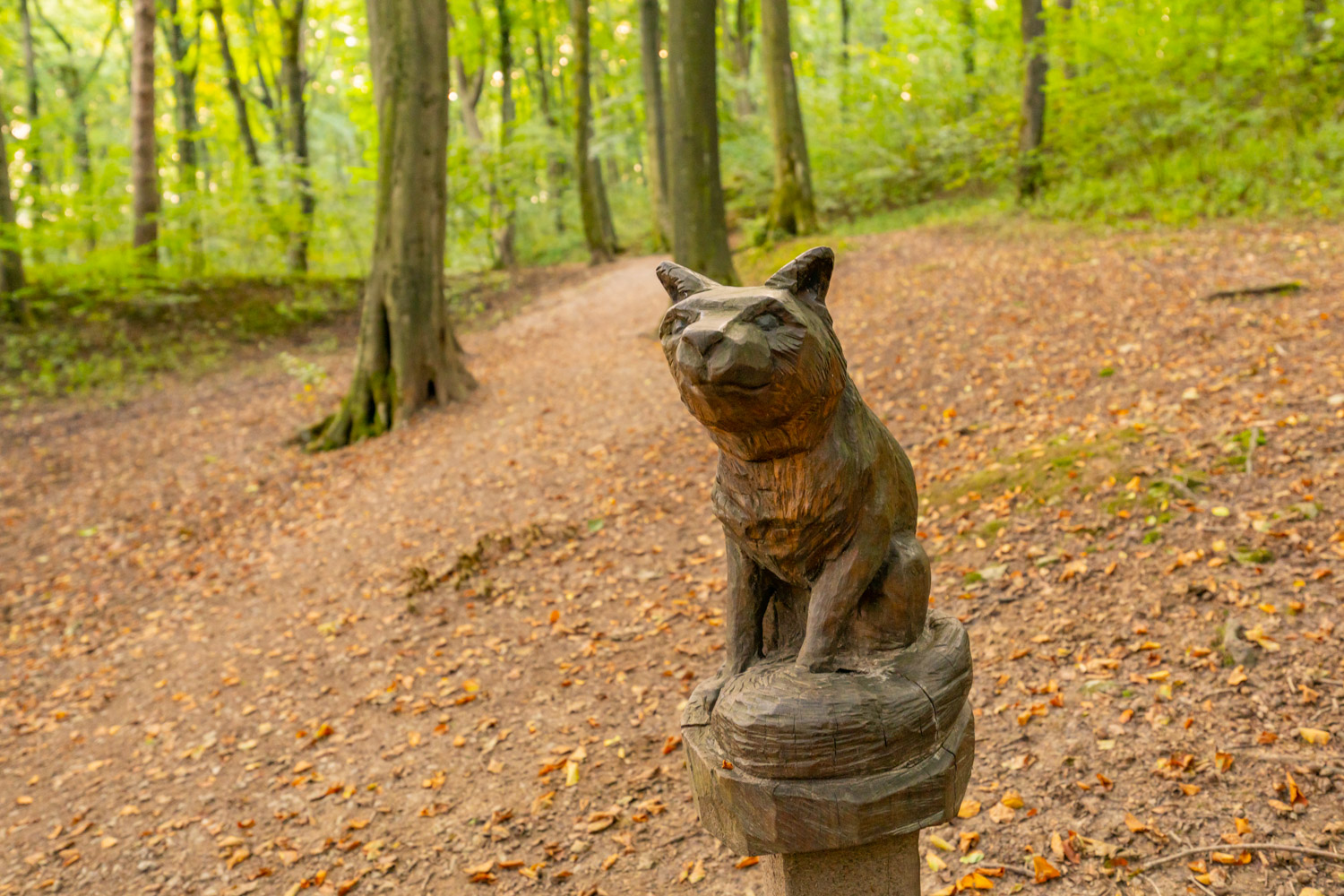 a statue of a cat in a forest