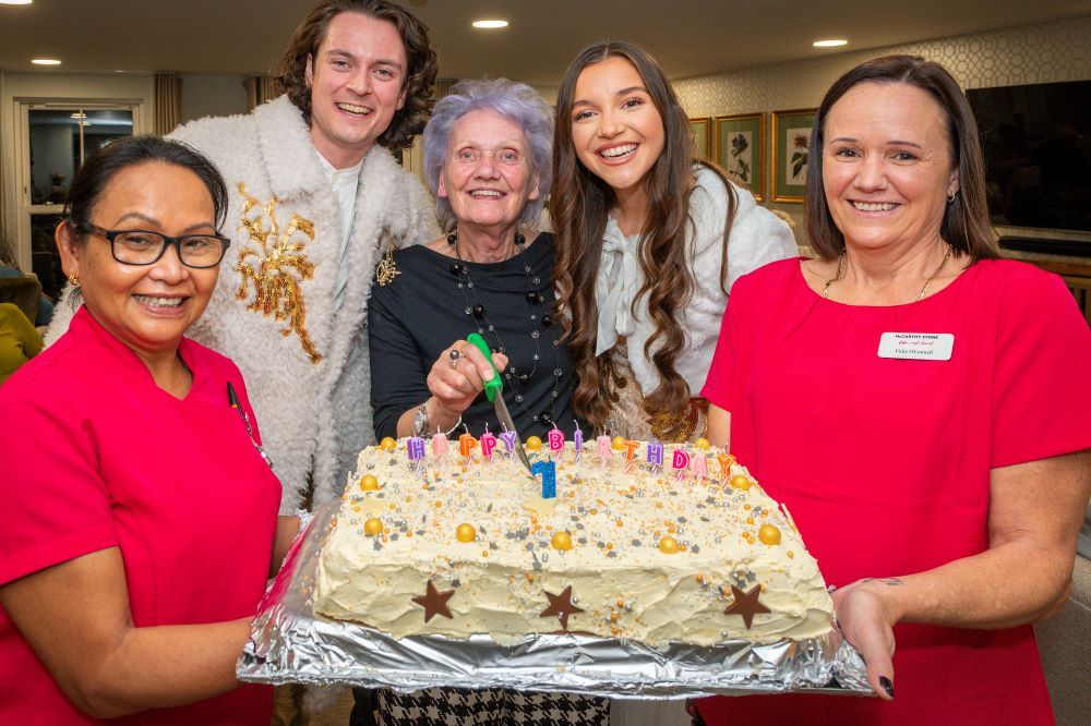 a group of women holding a cake
