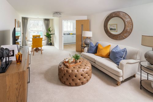 a living room with a white couch and a round mirror