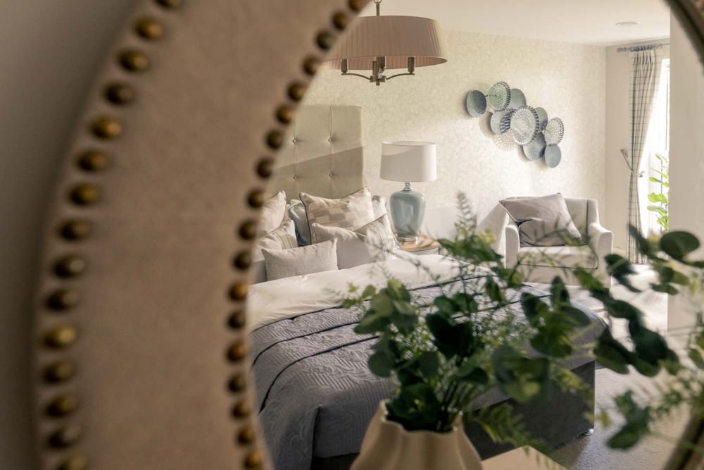 a bed with a table and a lamp on the wall