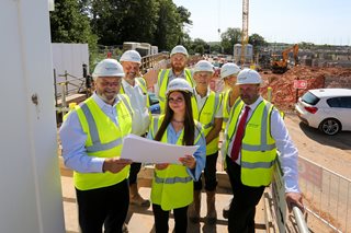 a group of people wearing hardhats and holding papers