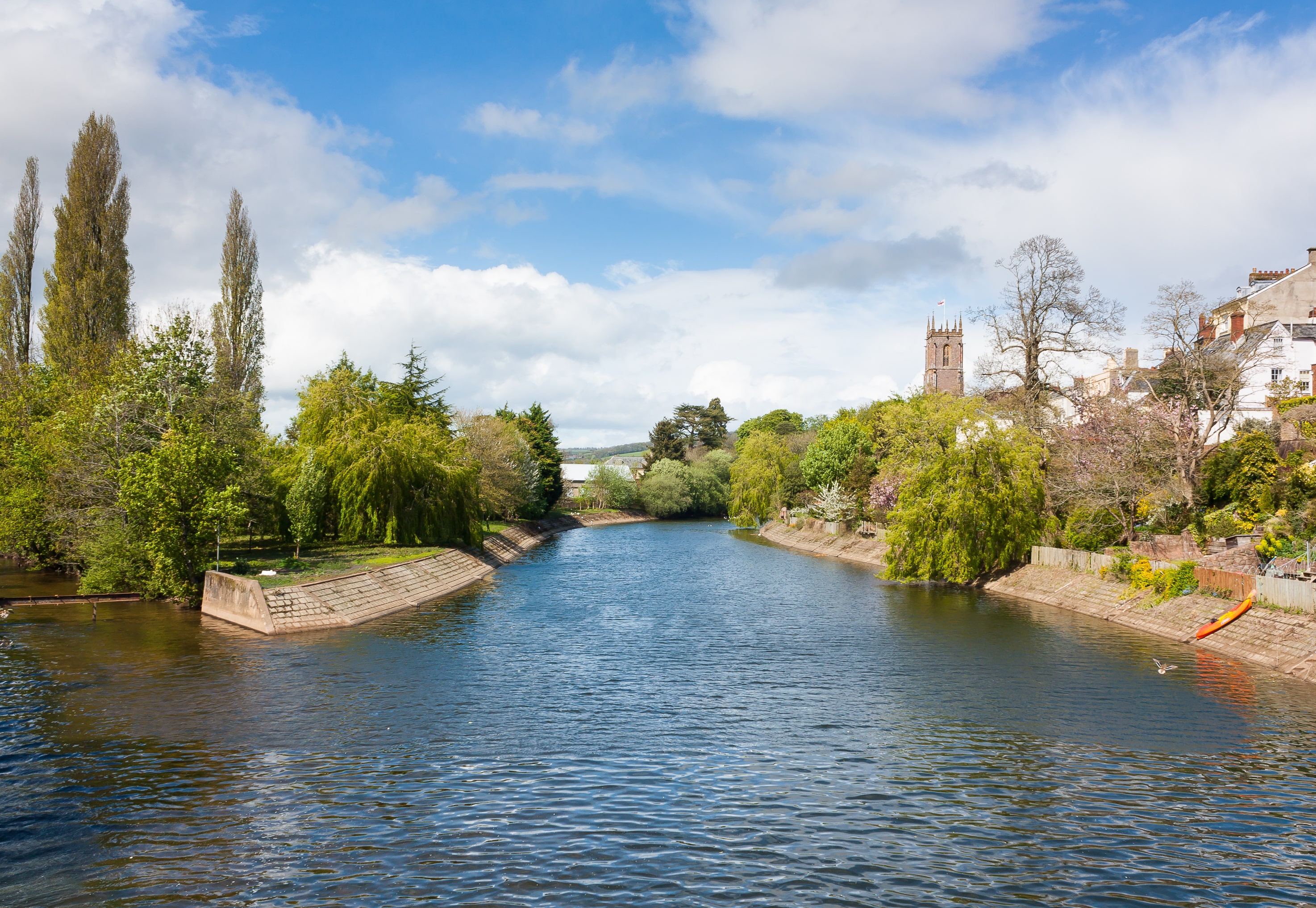 a river with trees and buildings along it