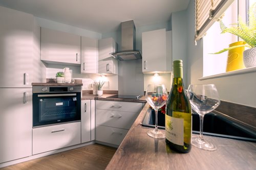 wine glasses and a bottle on a kitchen counter