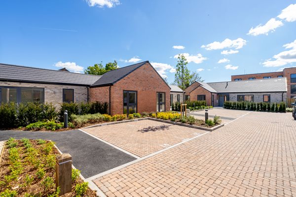 a brick road with bungalows either side of it
