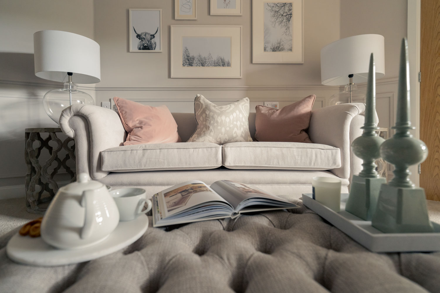 a white couch with pillows and a lamp on it