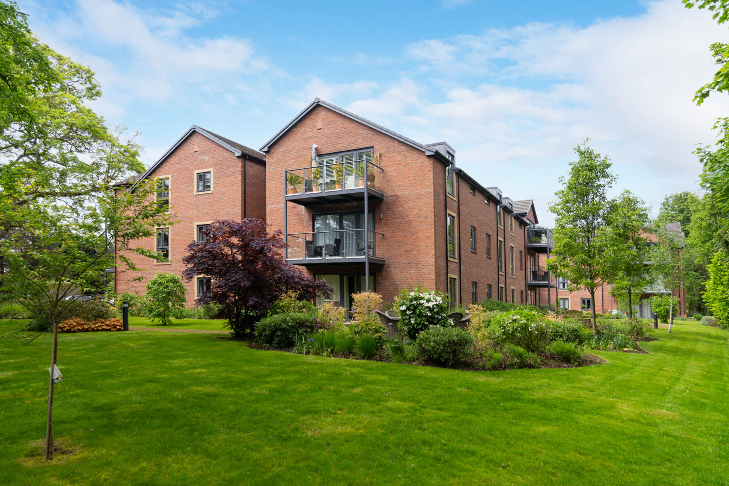 a brick building with trees and grass