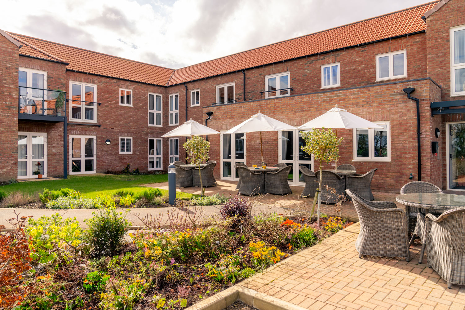 a brick building with a patio and tables and chairs