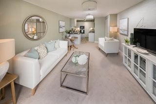 a living room with a white couch and a round mirror