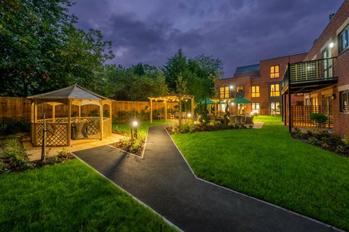 a backyard with a fence and a path leading to a house