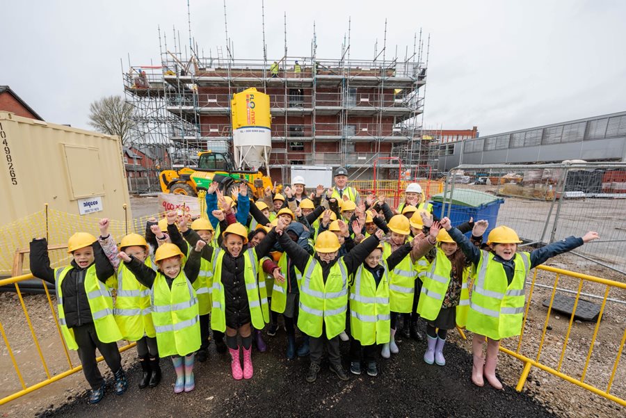 a group of people in yellow vests posing for a photo