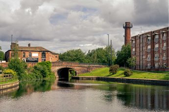 a river with a bridge and buildings in the background