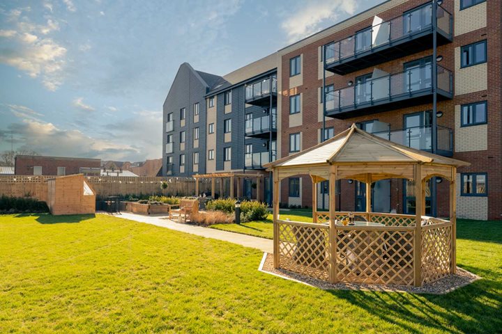 a building with a deck and a lawn in front of it
