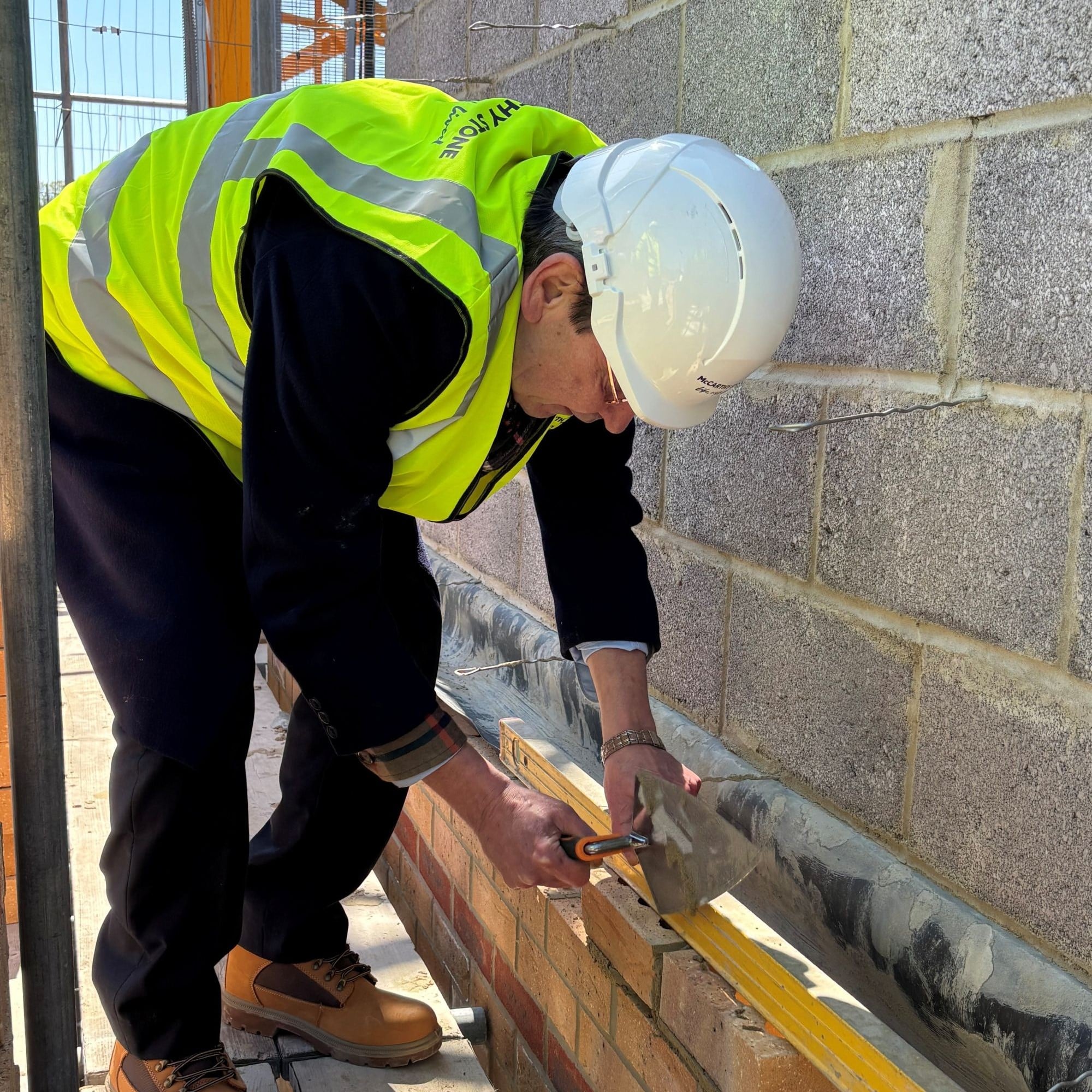 a person wearing a hard hat and holding a pipe