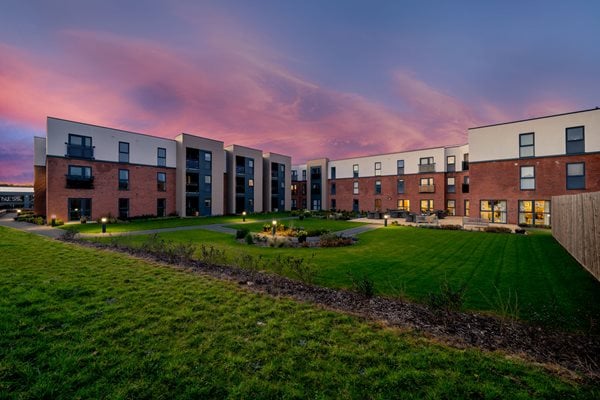 a row of buildings with a grassy field in front of them
