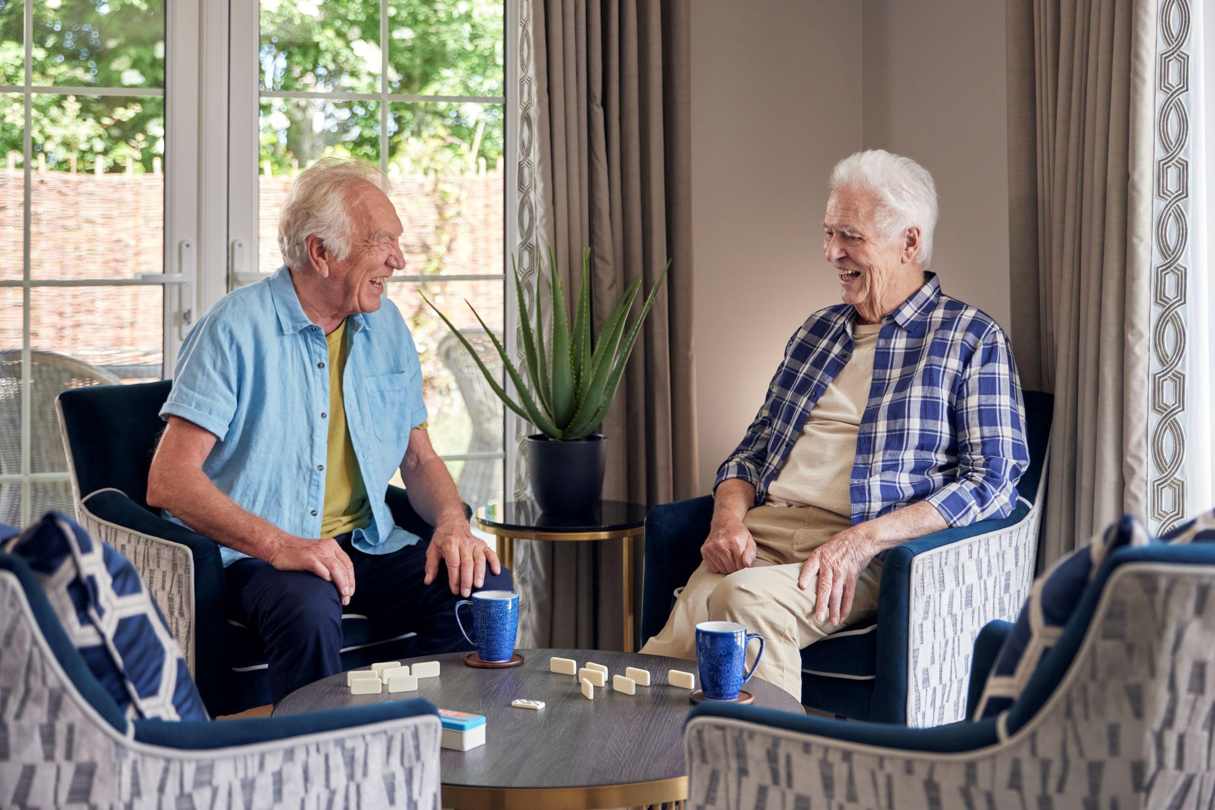 a couple of men sitting at a table with coffee cups