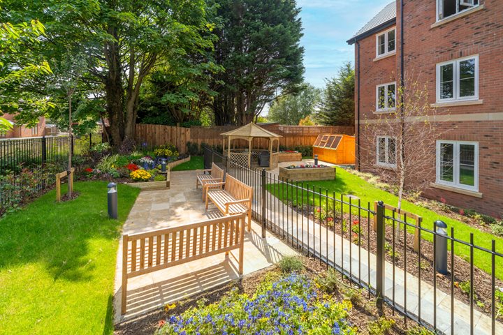 a fenced in yard with a bench and a building