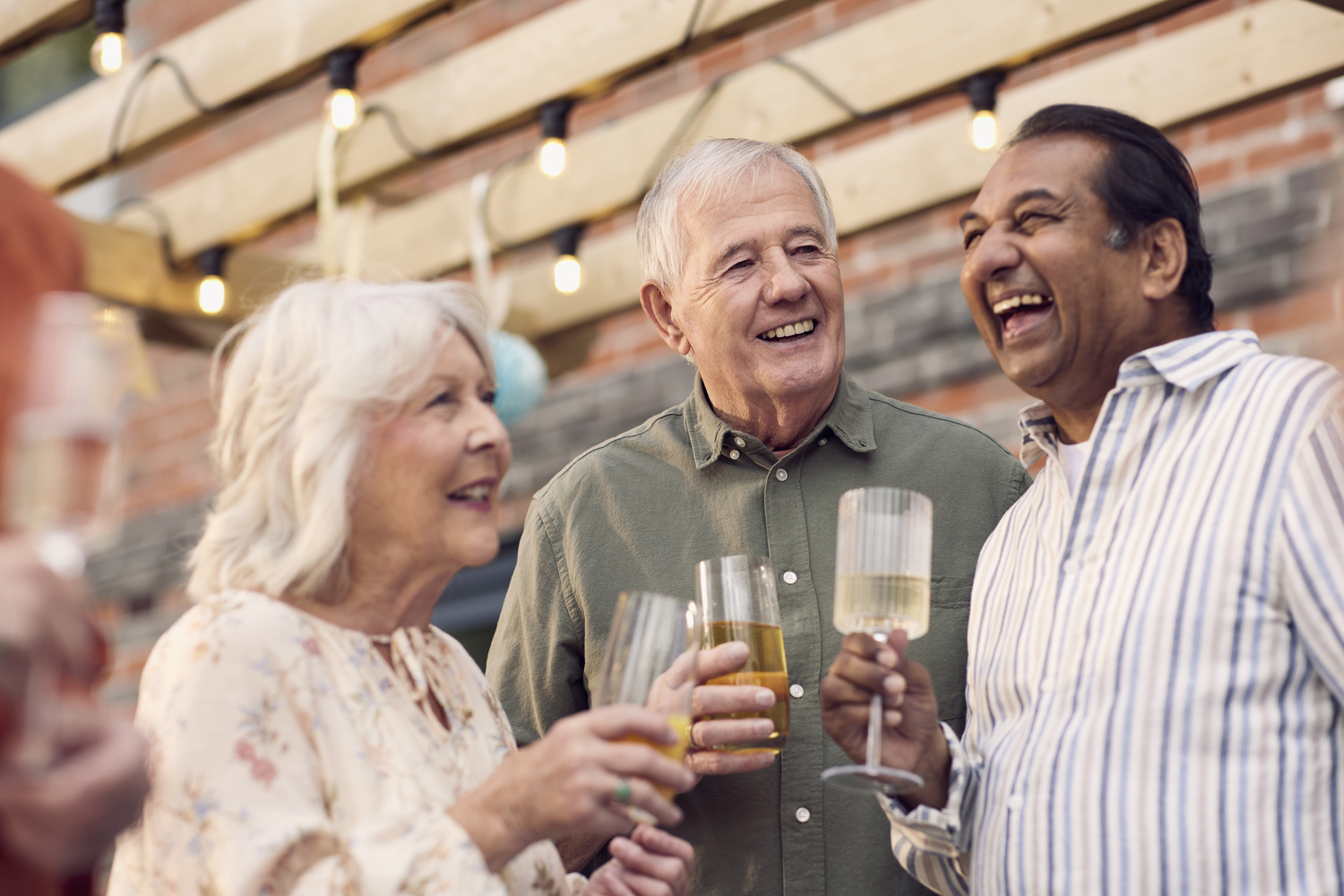 a few people laughing and drinking wine