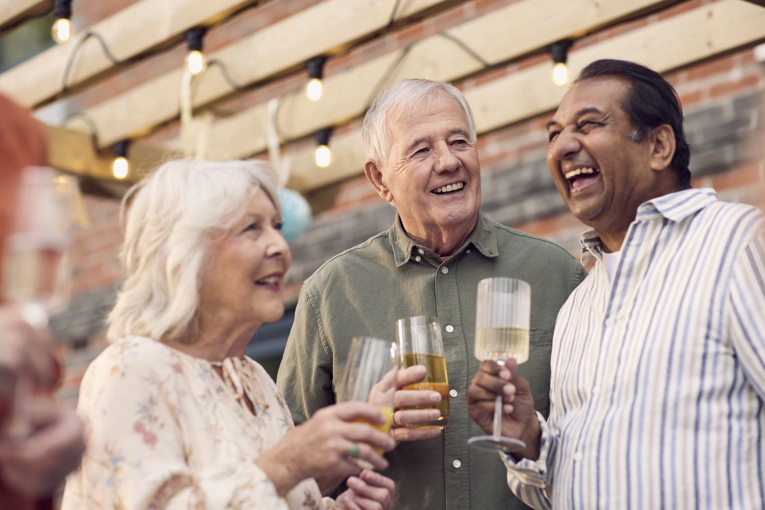 a few people laughing and drinking wine