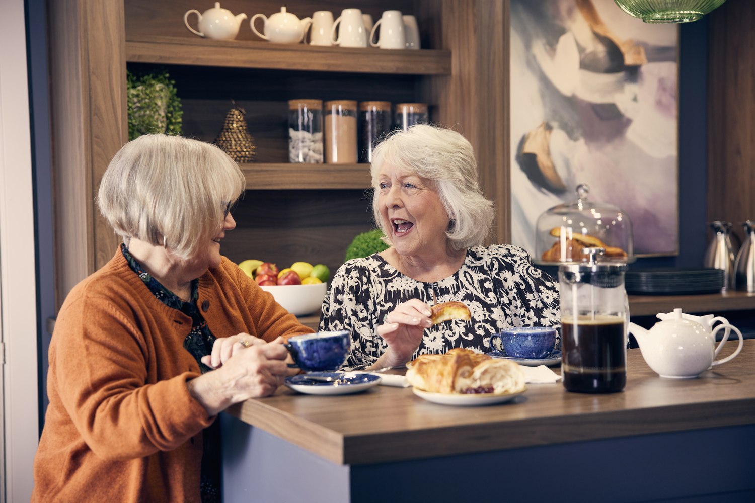 a person and an old woman eating at a table