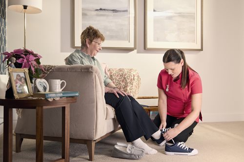 a woman sitting on a couch next to a man sitting on a chair