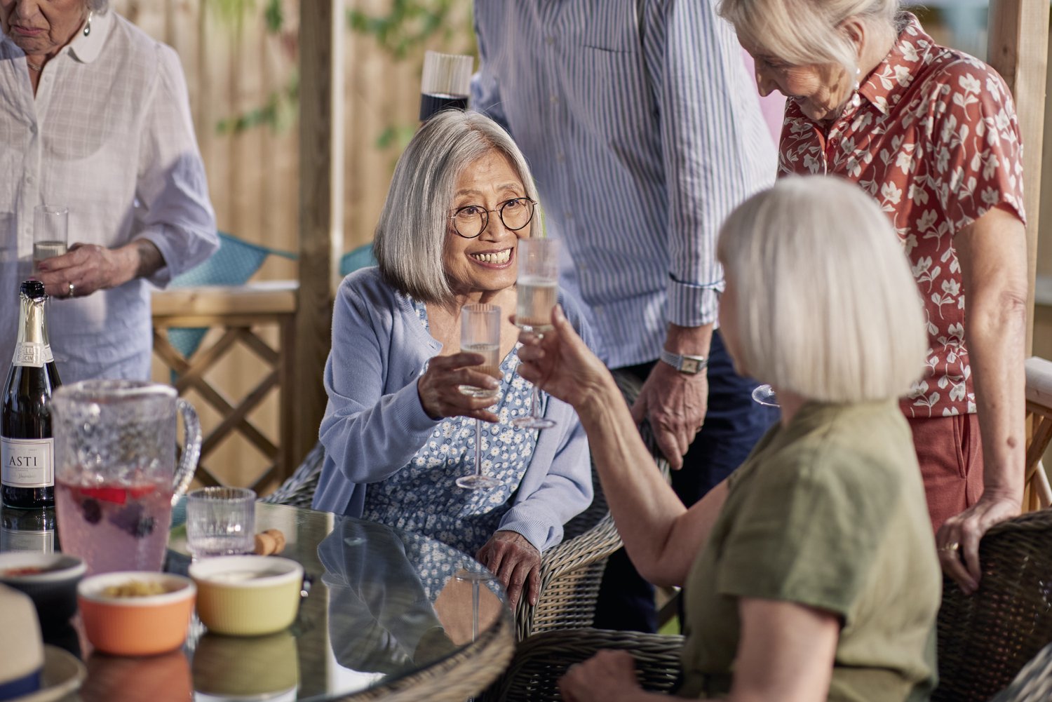a group of people standing around a table with wine glasses